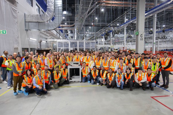 Prime Minister Trudeau, NextStar Energy employees gather around the first EV battery module produced at the plant.